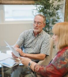 Man reviewing documents in an office with a woman